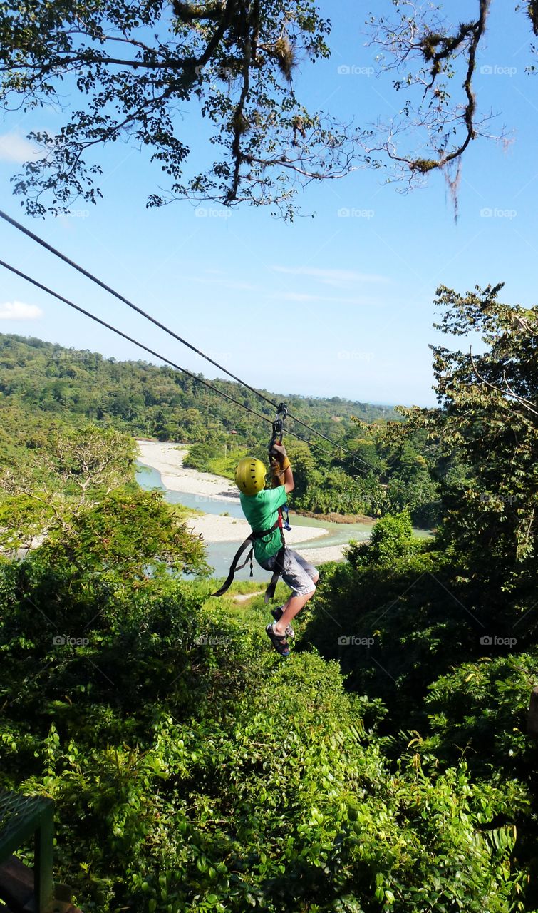 Fearless child zipping from Point A to Point B through the Costa Rican rainforest canopy