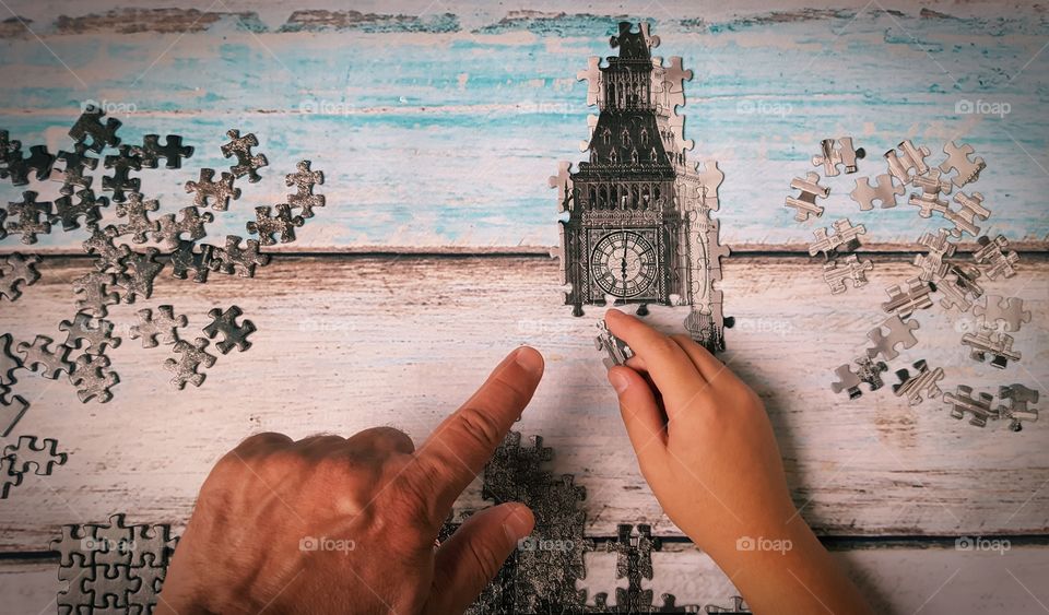 Man helping the boy to put the puzzle piece