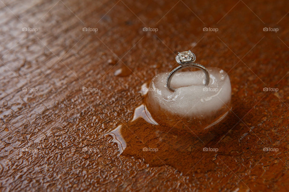 Diamond engagement ring melting away in an ice cube