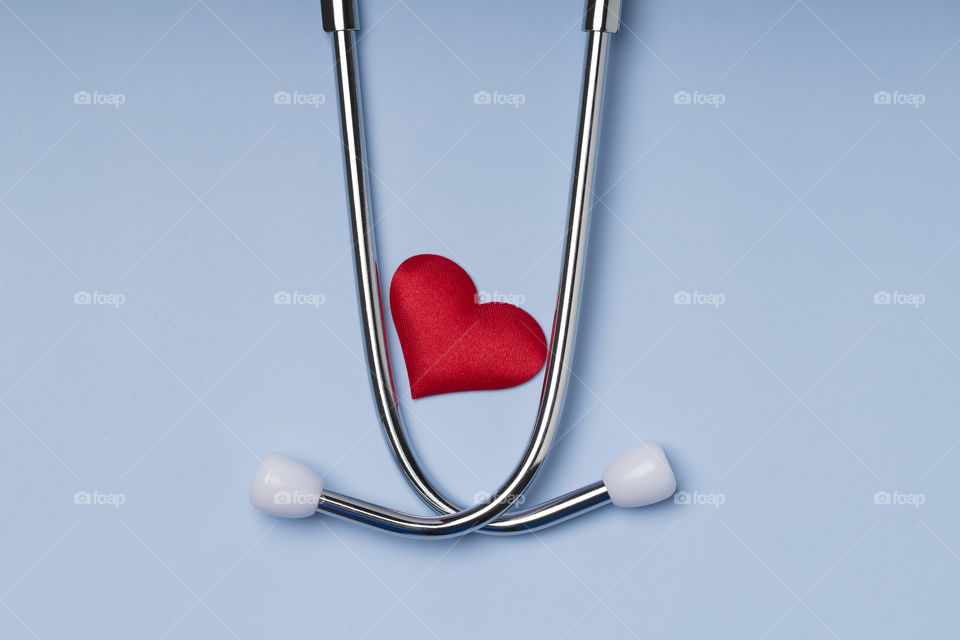 stethoscope and red heart on blue background.  cardiology concept