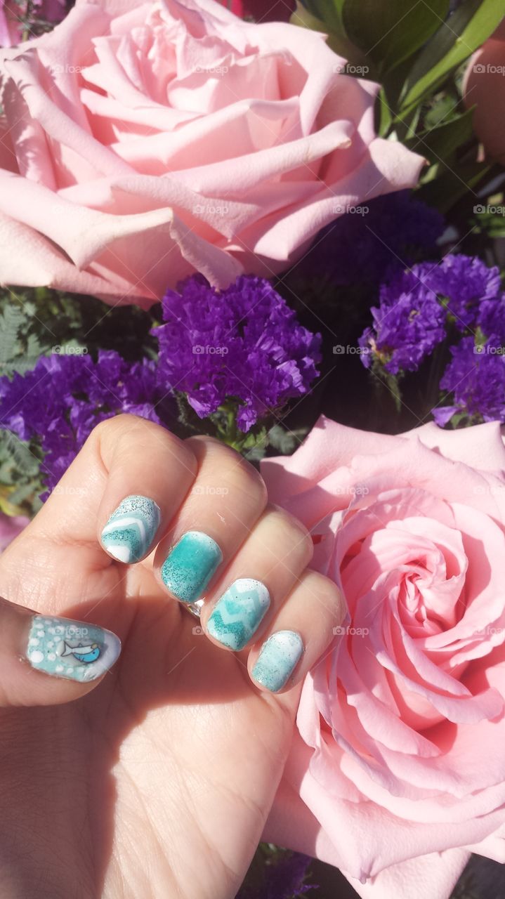 Teal nail art polish cute design, flowers in background, pink rose, violet carnations, flower arrangement