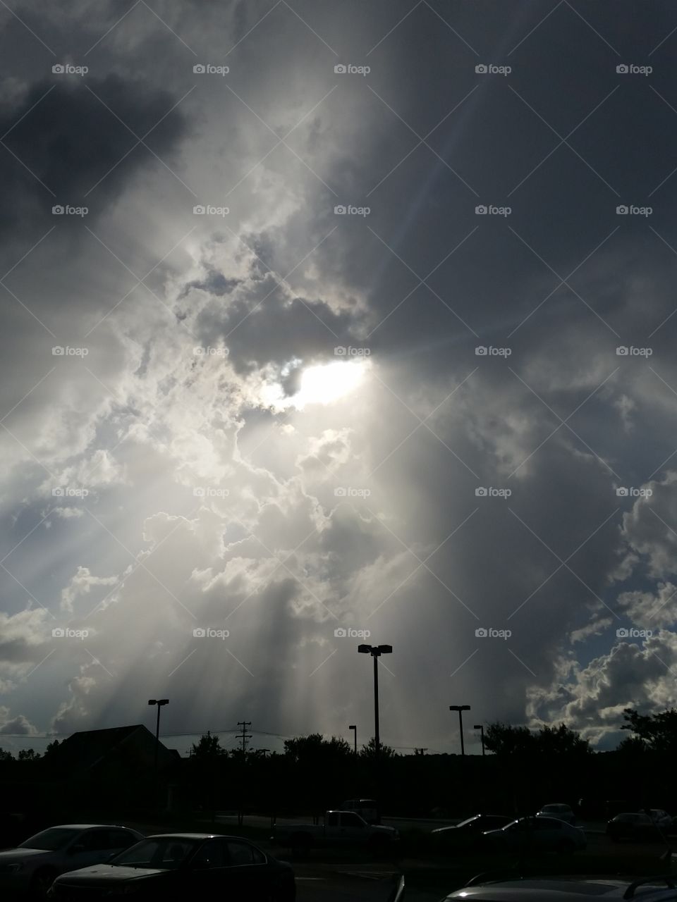 sun shining through dark clouds in black & white