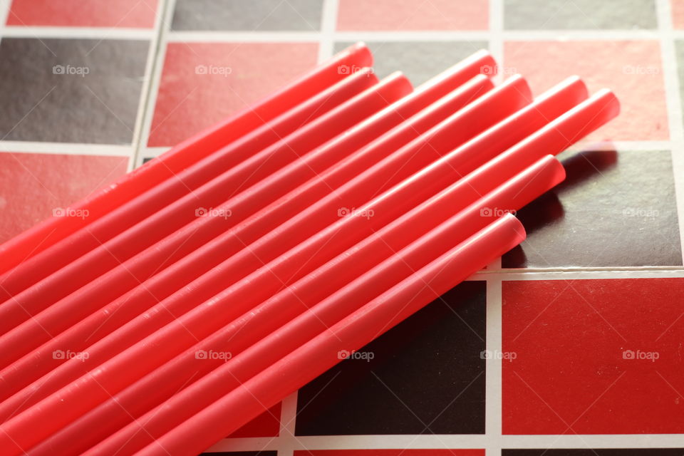 Red straws on red and black background 