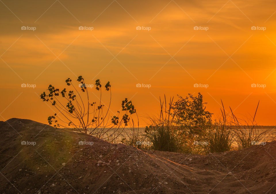 Sand dune illuminated by sunrise in Lake Michigan 