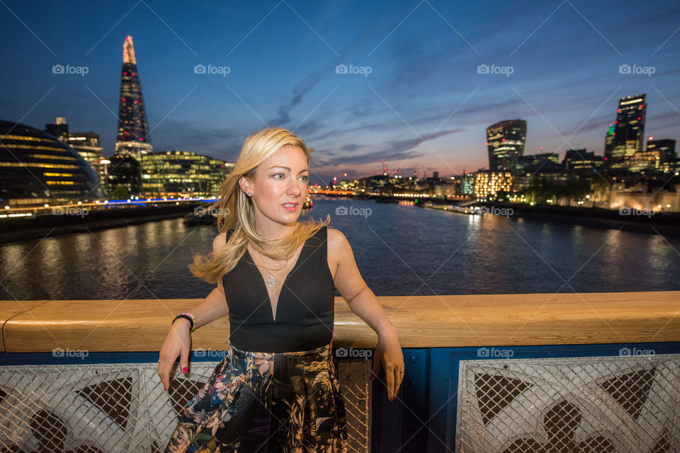 Woman 33 years old tourist from Sweden posing on London bridge, behind her London skyline.