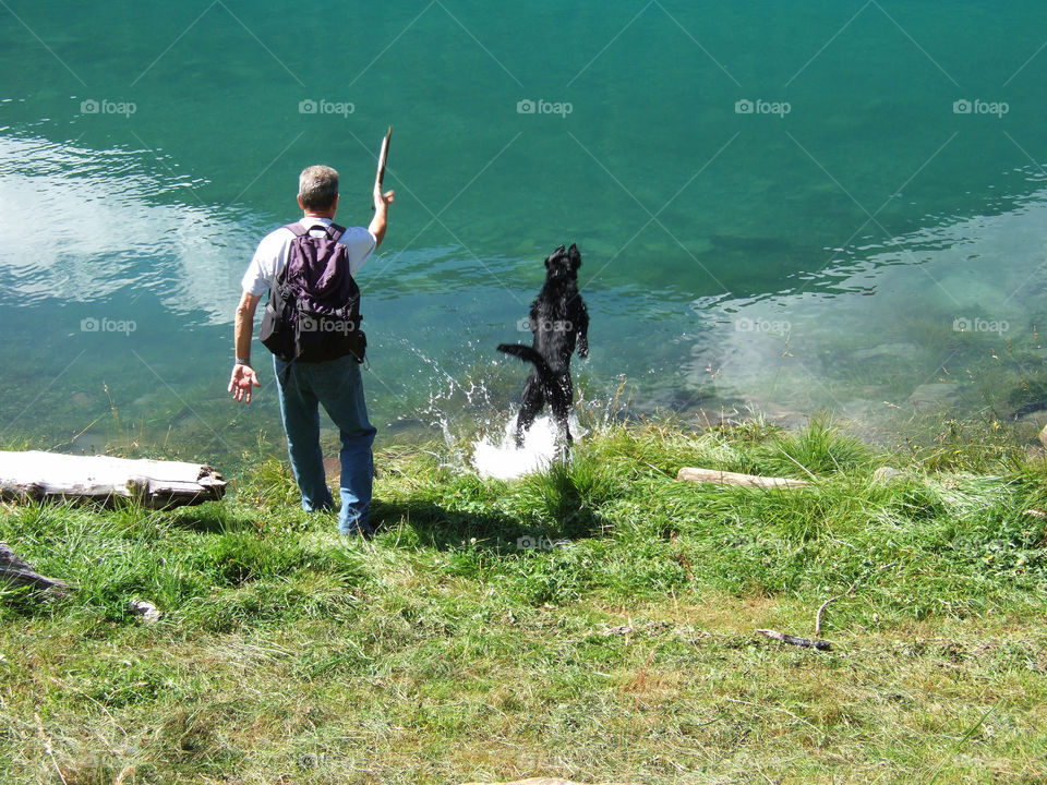 Man plays with his dog - Lake Vernago (Senales Valley), South Tyrol, Italy.