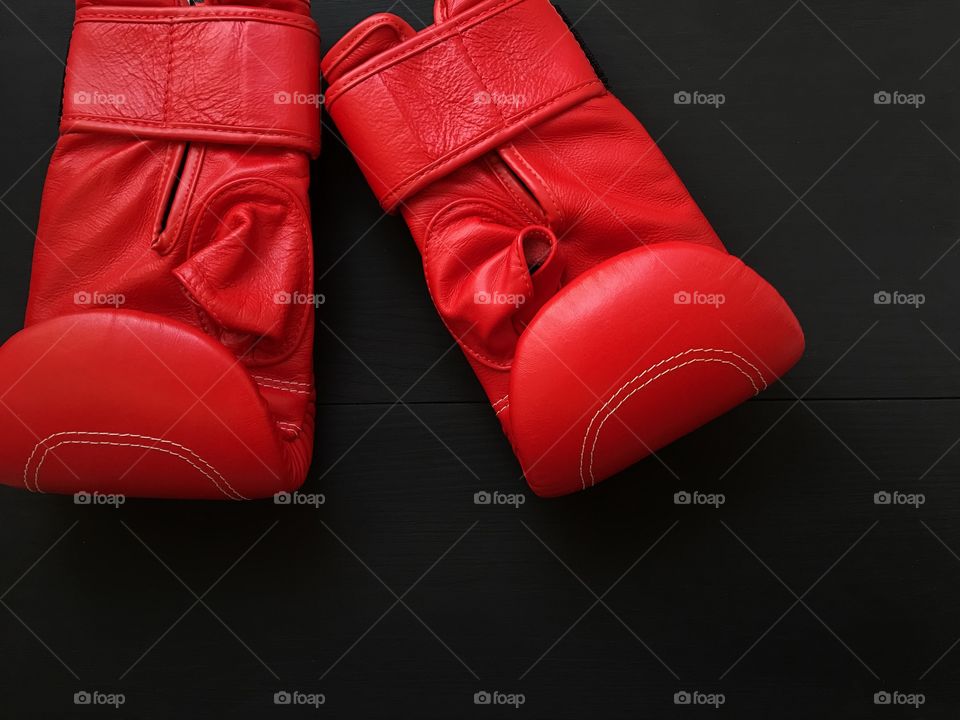 Boxing red gloves for sports, boxing, top view on a black wooden background
