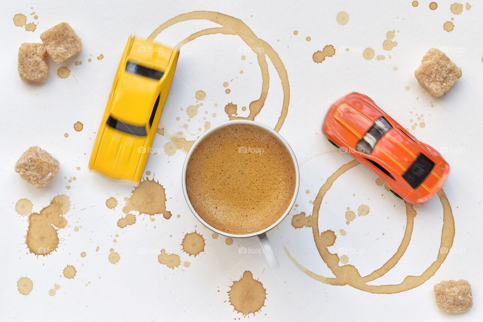 Cars making doughnuts around the coffee cup 