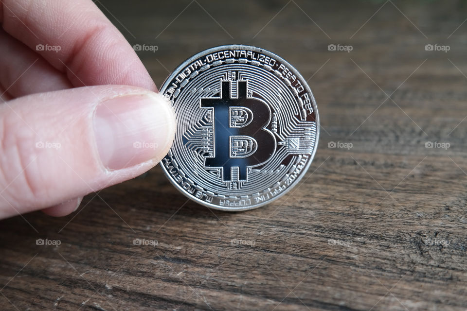 Holding a silver bitcoin