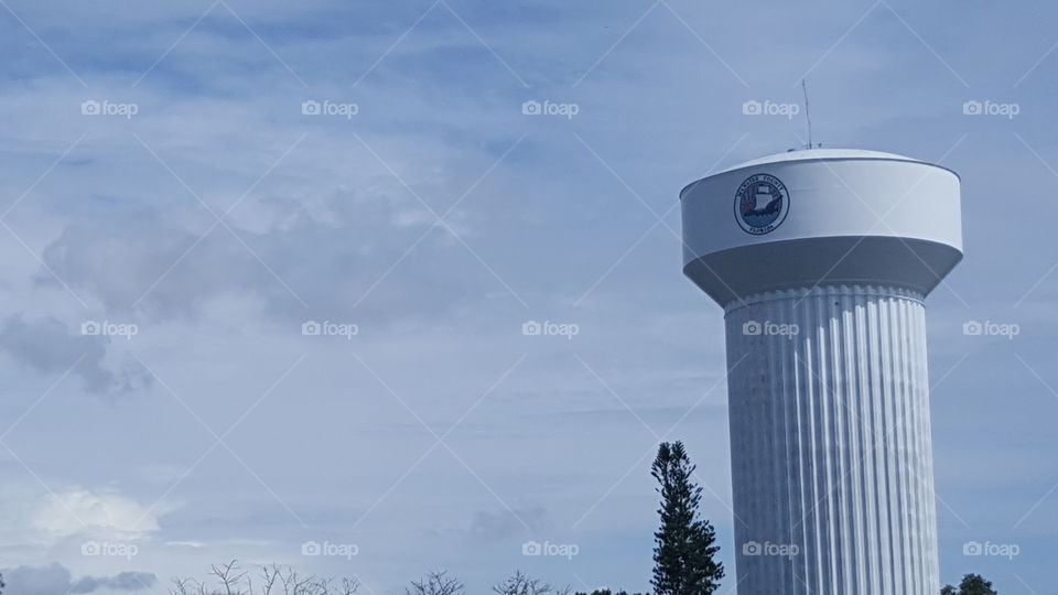 The water tower stands high into the clouds.