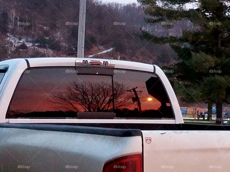 Capturing a sunset in the back window of a pickup truck.