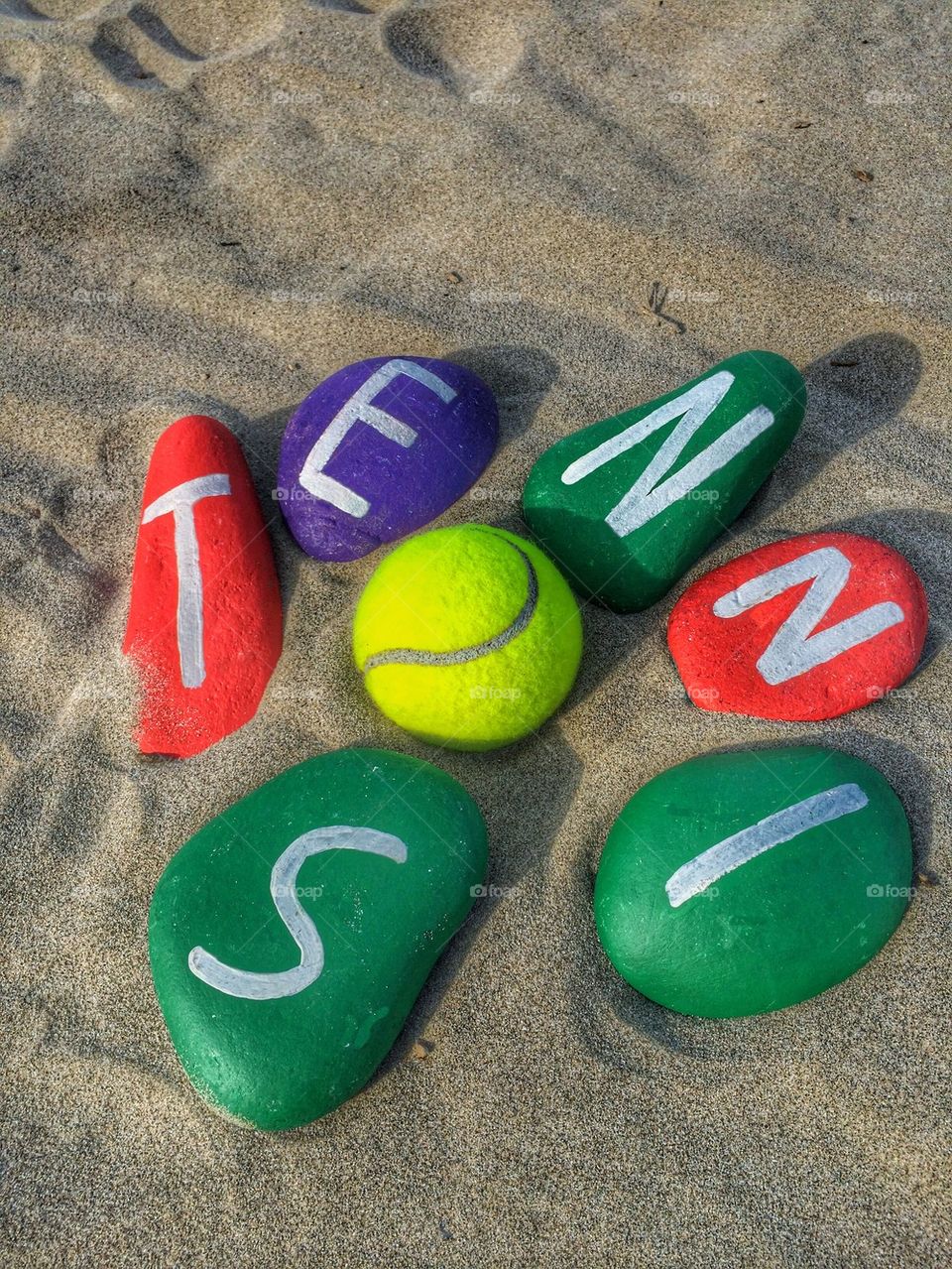 Tennis concept on stones with a yellow ball