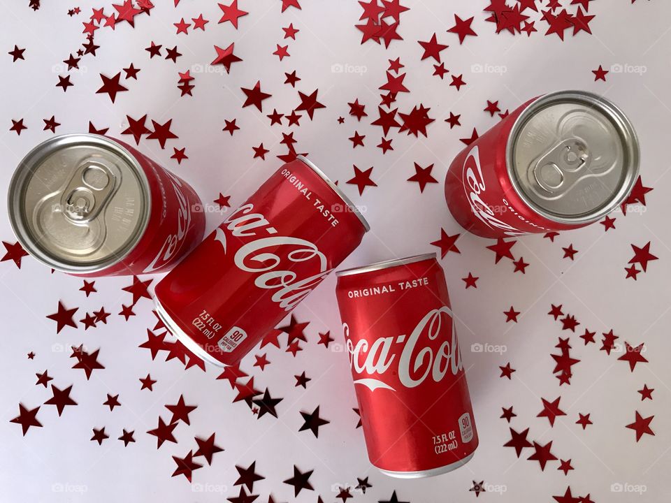Coca Cola on a white background with red stars flat lay