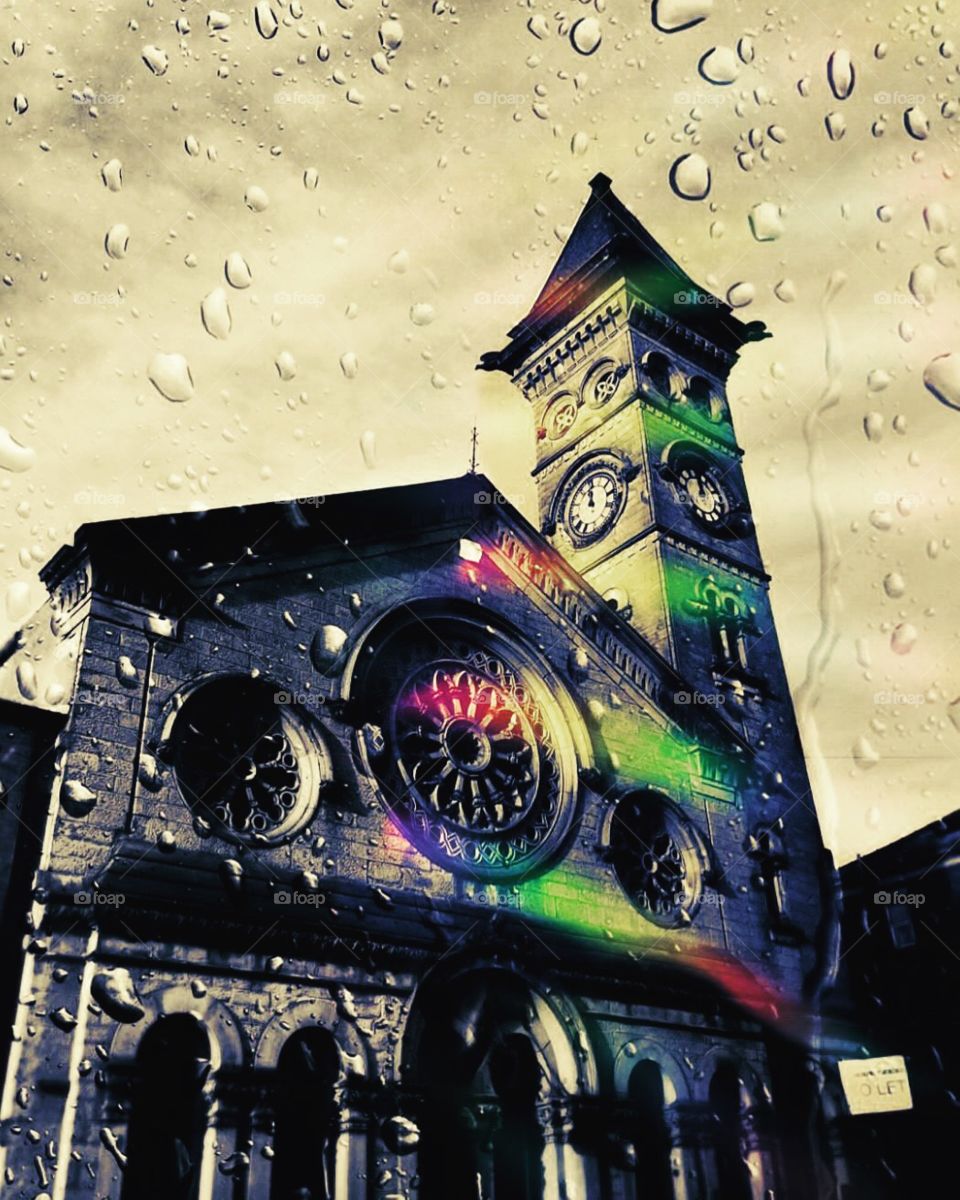 A Clocktower Viewed Through The Glass Of A Cafe In England During A Rainstorm 