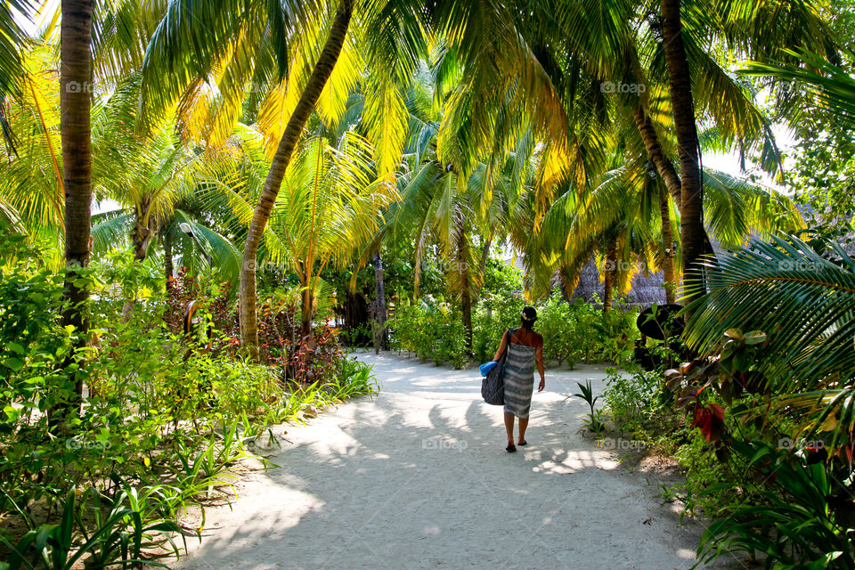 Woman walking on palm garden