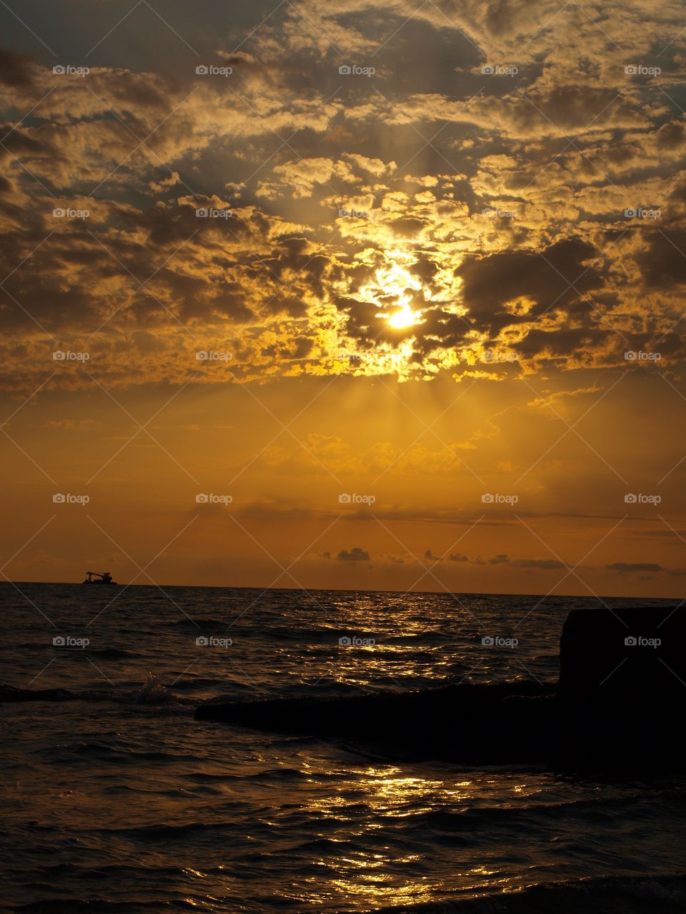 View of a sea against dramatic sky at sunset