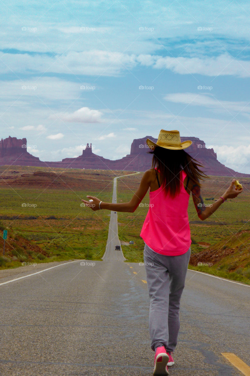 Woman walking on the road called I 163 to Monument valley,Utah