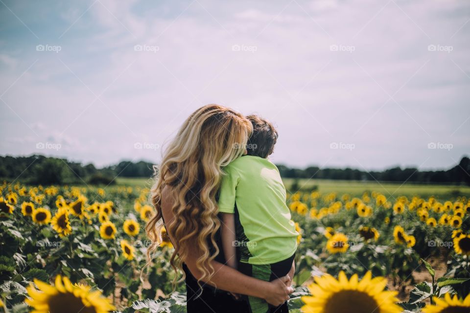 Mommy and son in sunflower field 