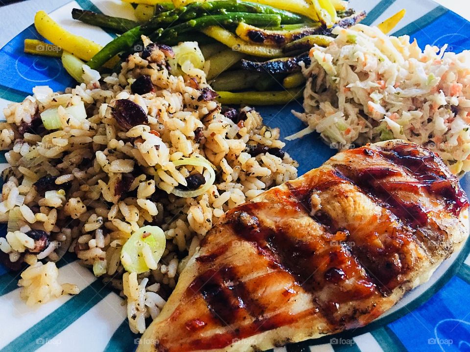 Healthy summer meal. BBQ Chicken breast plate with rice, asparagus and yellow beans and serving of creamy coleslaw 