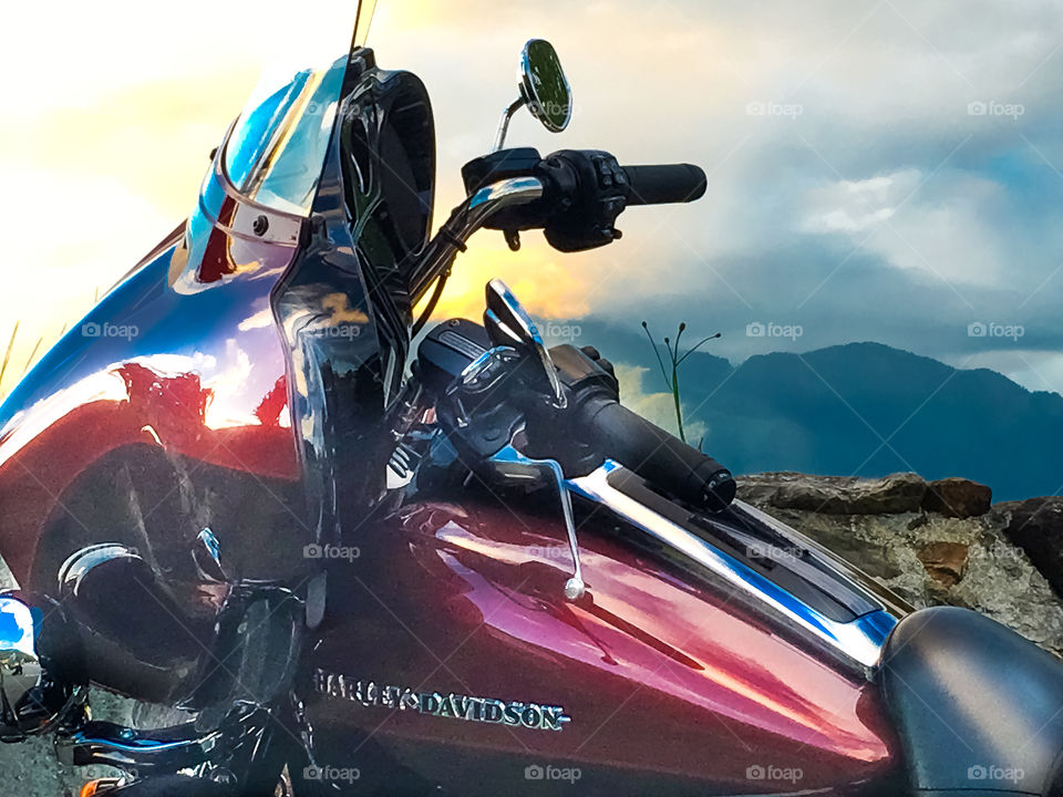 Harley Davidson Hog  Motorcycle lakeside at sunset against stormy sky