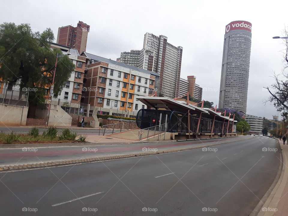 A beautiful bus stop along the busy street.