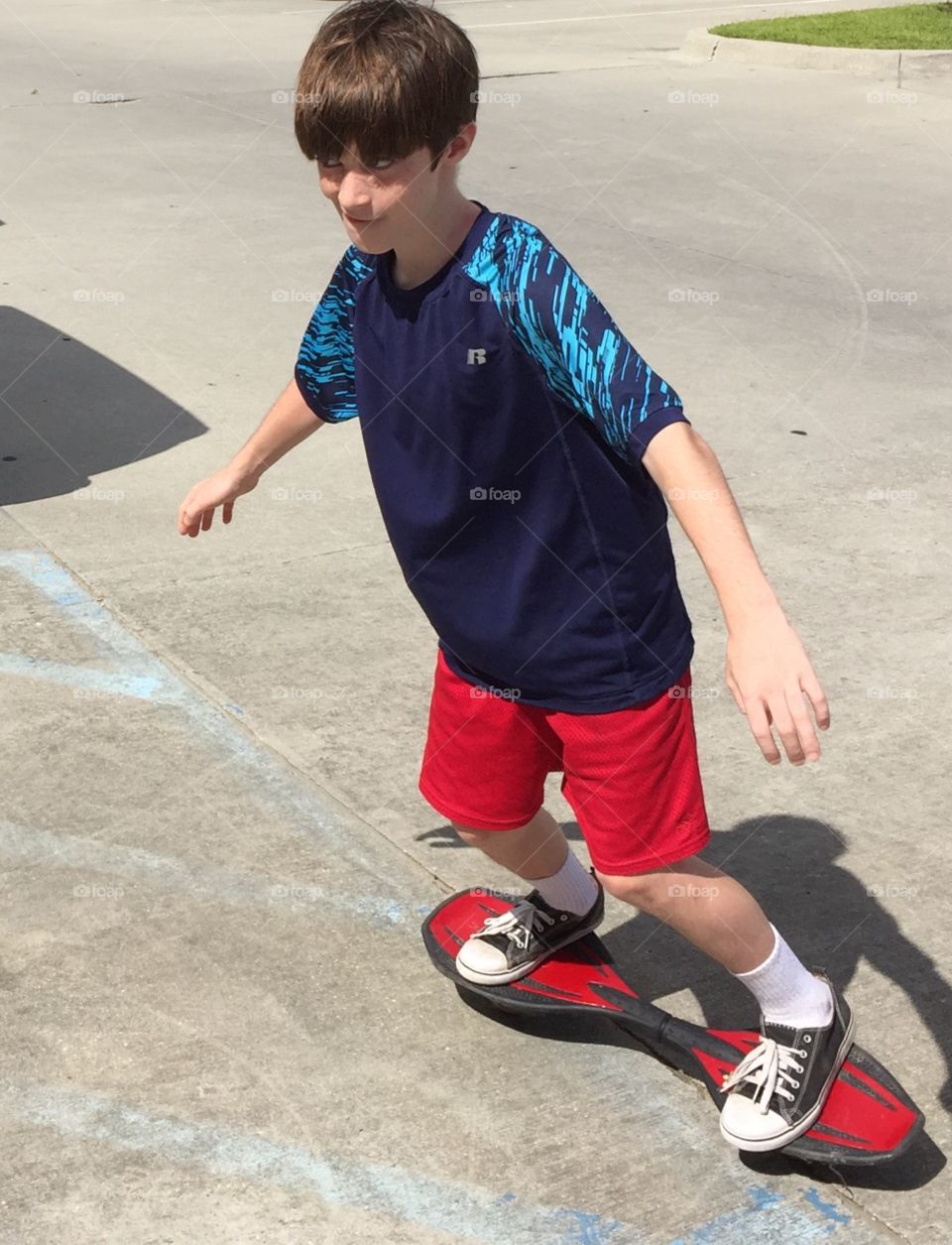 Young boy with his rip board, sailing around the parking lot in Louisianna.