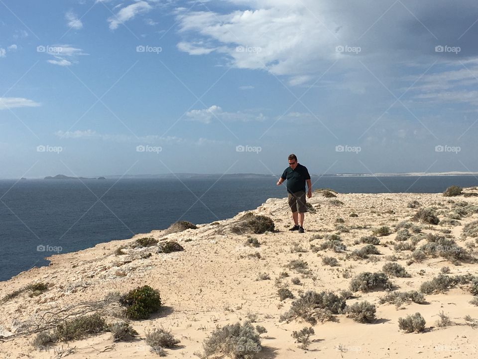 Man walking on ocean cliff