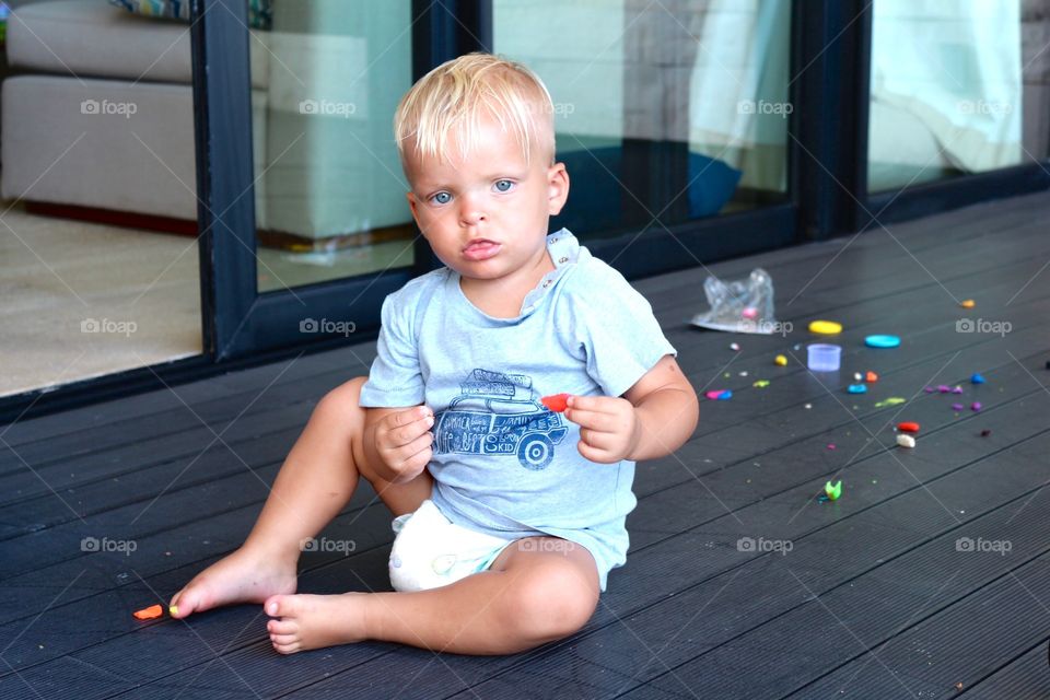 Cute blue eyed baby playing with toys 
