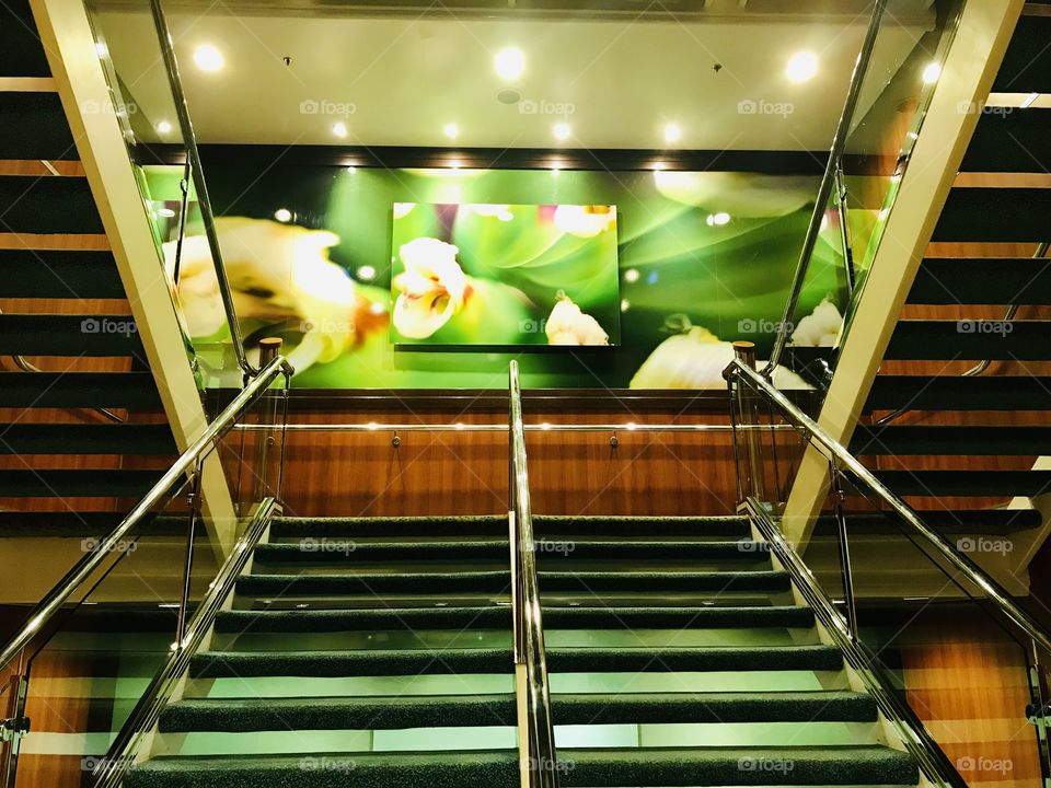 Gorgeous photo of stairway and green and white flower wall hanging in beautiful area! 