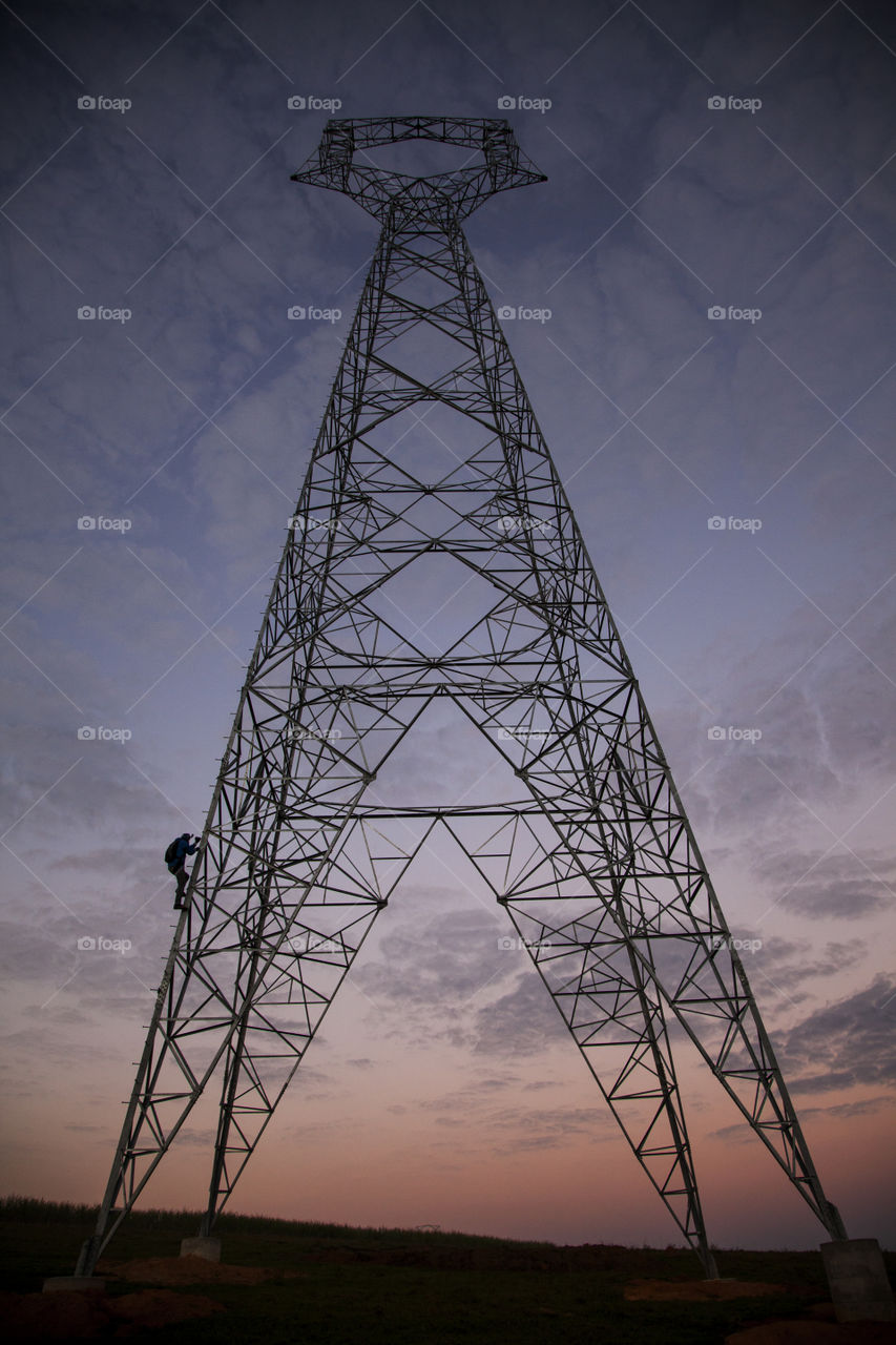 man clibing a power tower