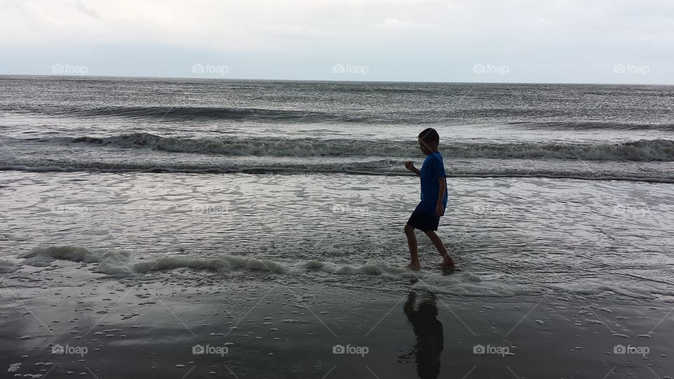 Beach Hopper. A young boy hopping in the waves at Edisto Beach on a warm spring April day.