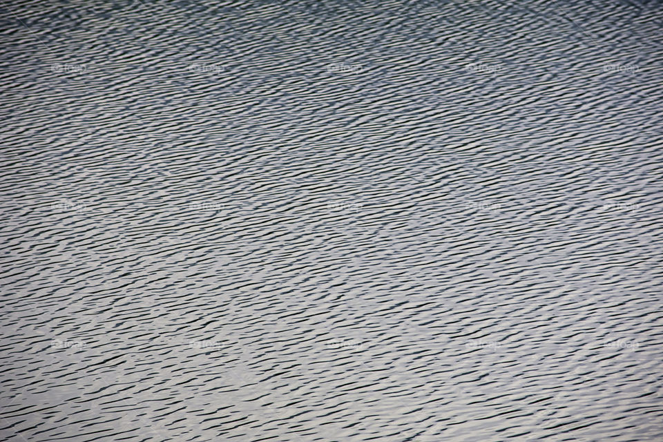 Blurry water waves by wind and sunlight reflecting surface