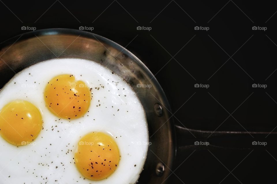 Three Sunnyside up eggs in frying pan