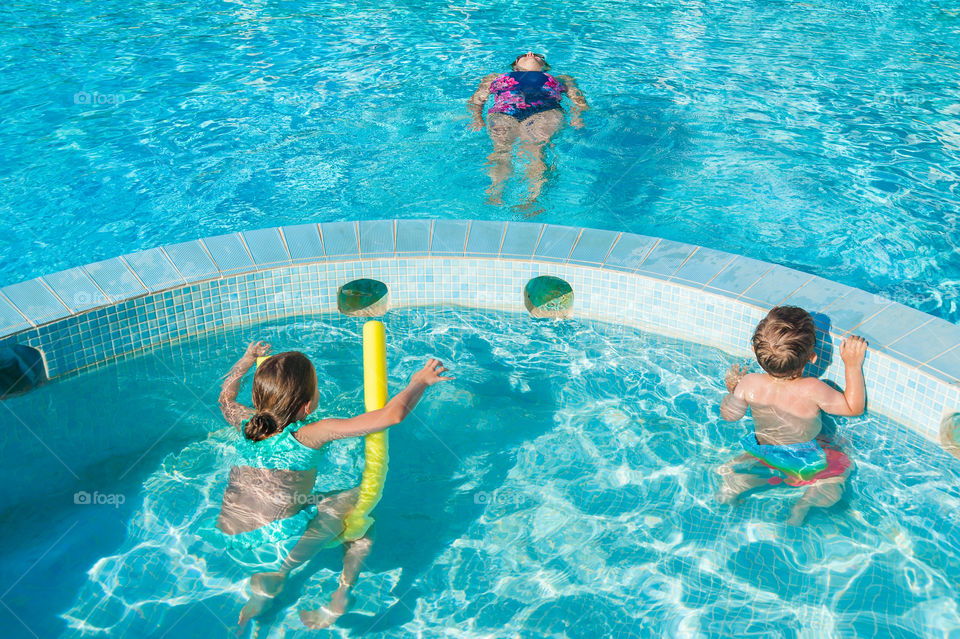 Leisure and play time for family in swimming pool.