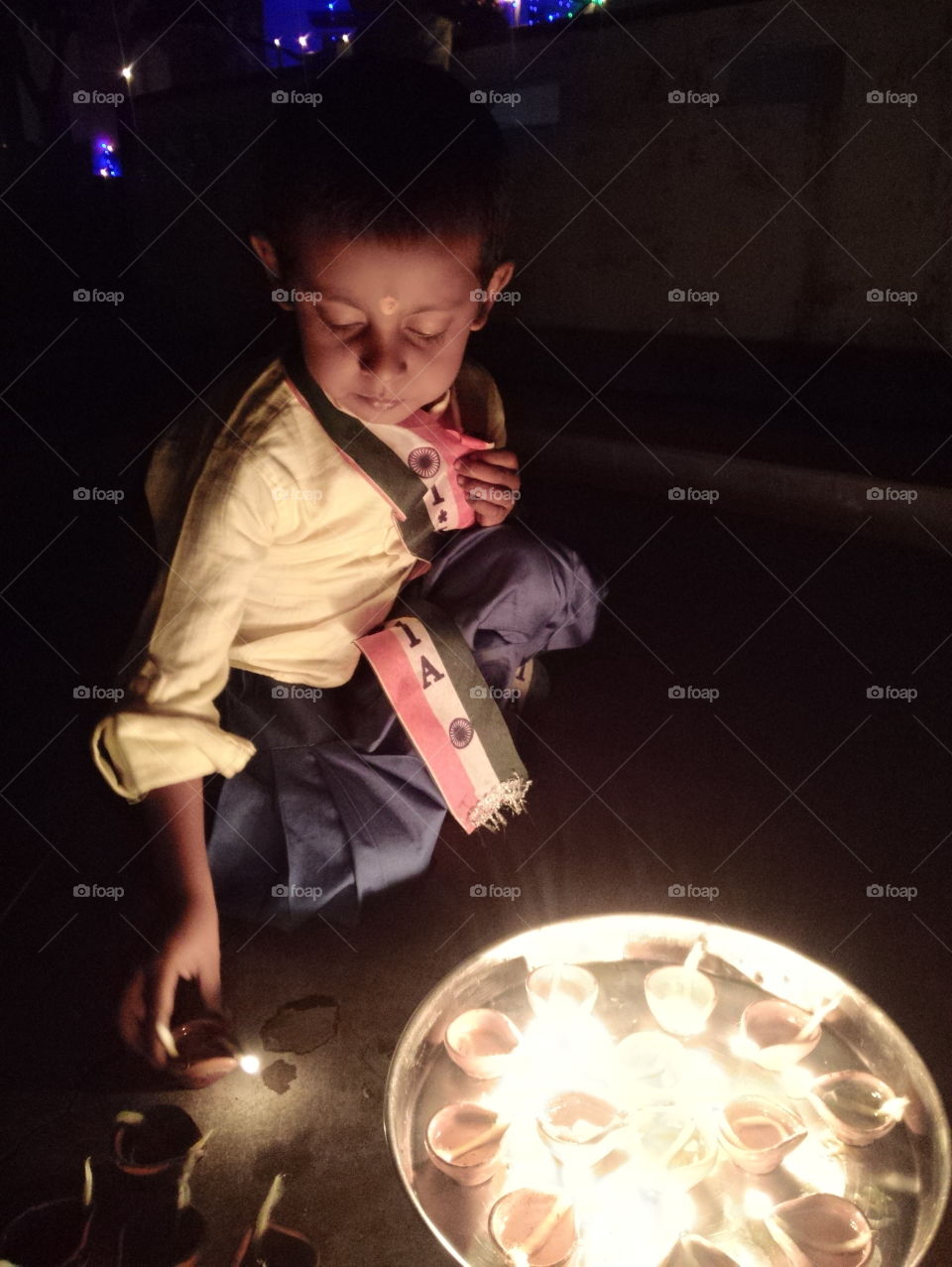 indian boy celebrating deepawali,indian kid candal burning, candal lighting, celebrating indian independence day, deep,diwali, indian boy with deep diwali, dev dipawali Varanasi,