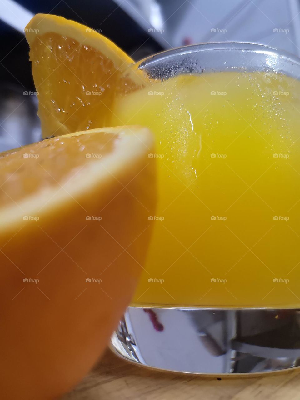 A glass of freshly squeezed orange juice with ice cubes