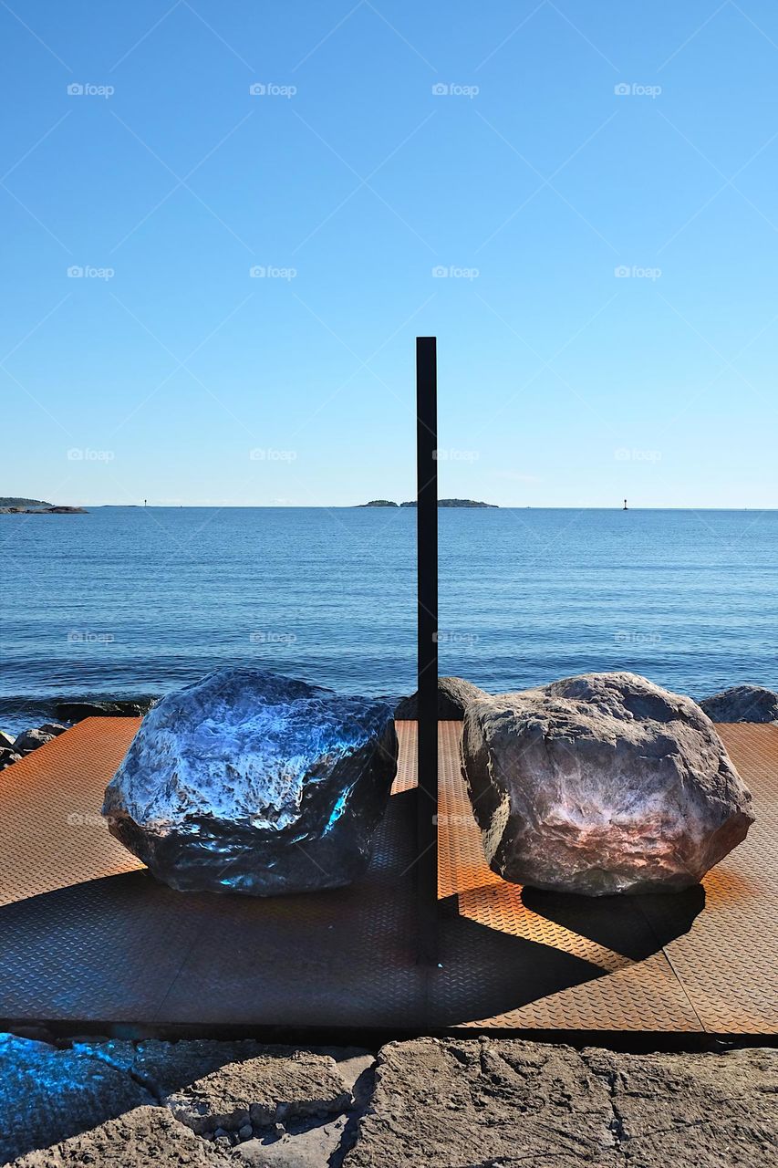 Reflection in the mirror: open air museum installation two big rock on both sides of the mirror on the Vallisaari island