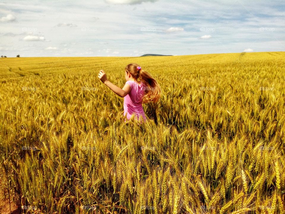 A beautiful scenery in a bulgarian field in the summer with a girl running through