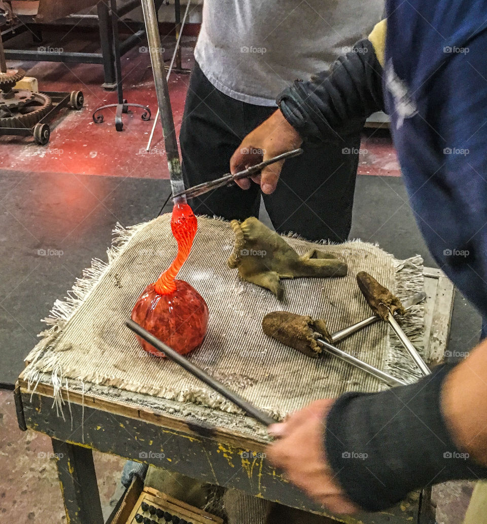 Forming the pumpkin stem. The glass is like liquid, but they only have seconds to create the shape they want. 