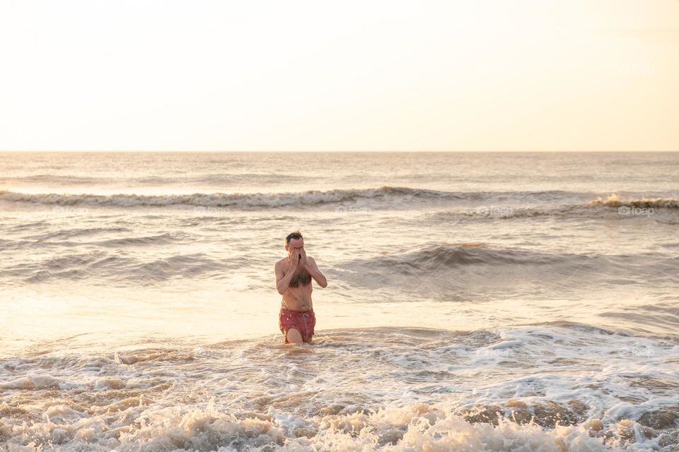 man swimming in the ocean at dawn