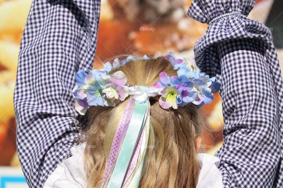 Flower violet crown on blond girl wearing Cornish costume at outdoor festival 