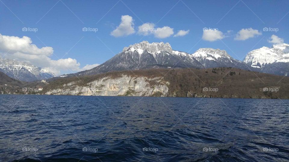 View of large, snowy mountain from a boat on a lake.