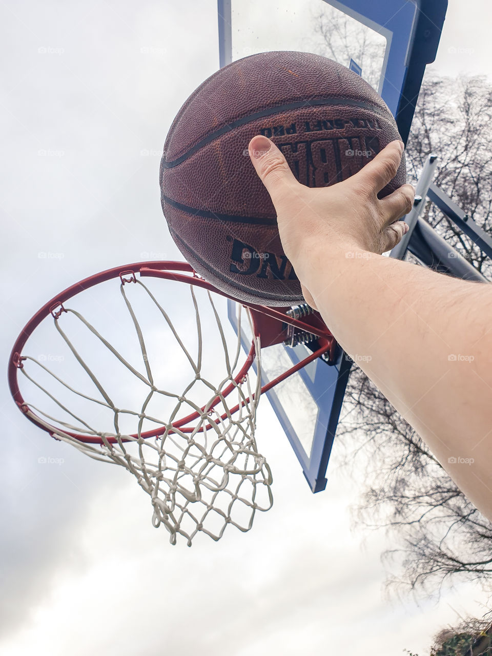 A portrait of the arm and hand og someone with a basketball ready to throw it into the basketball ring or hoop. maybe it will be an easy lay-up or a spectacular dunk