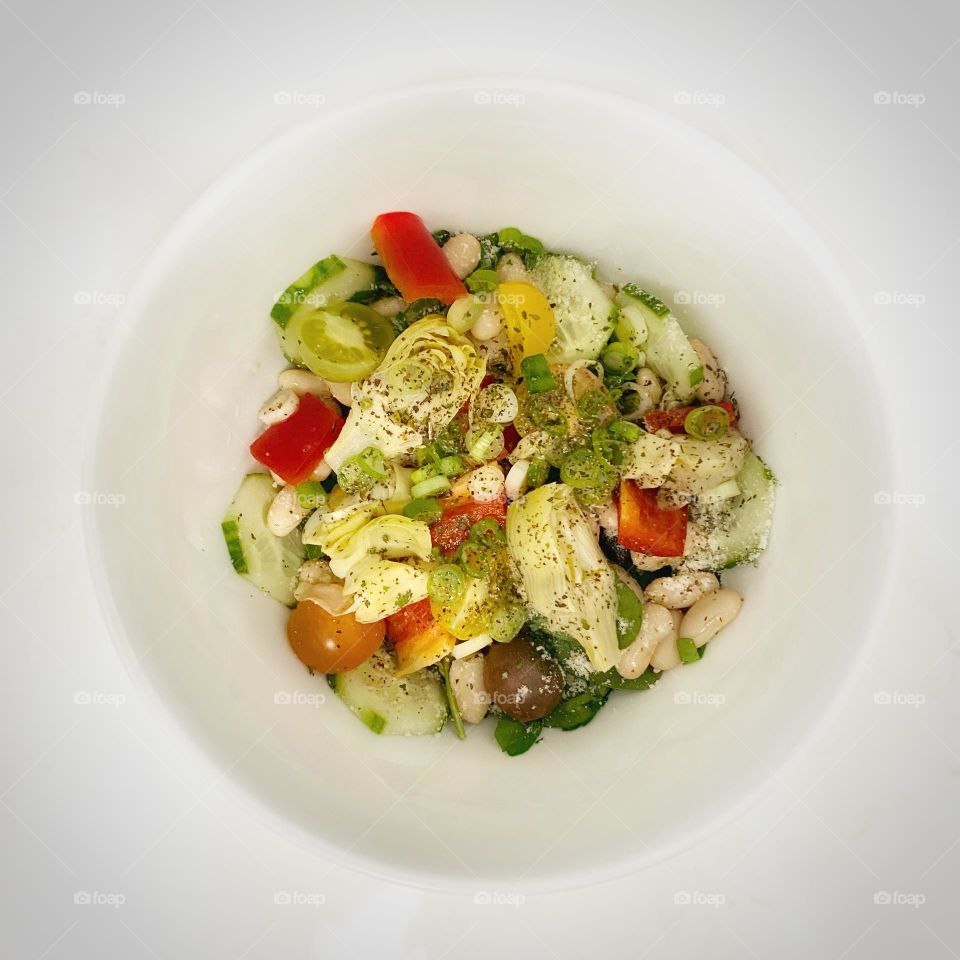 Salad in a white bowl on a white countertop 