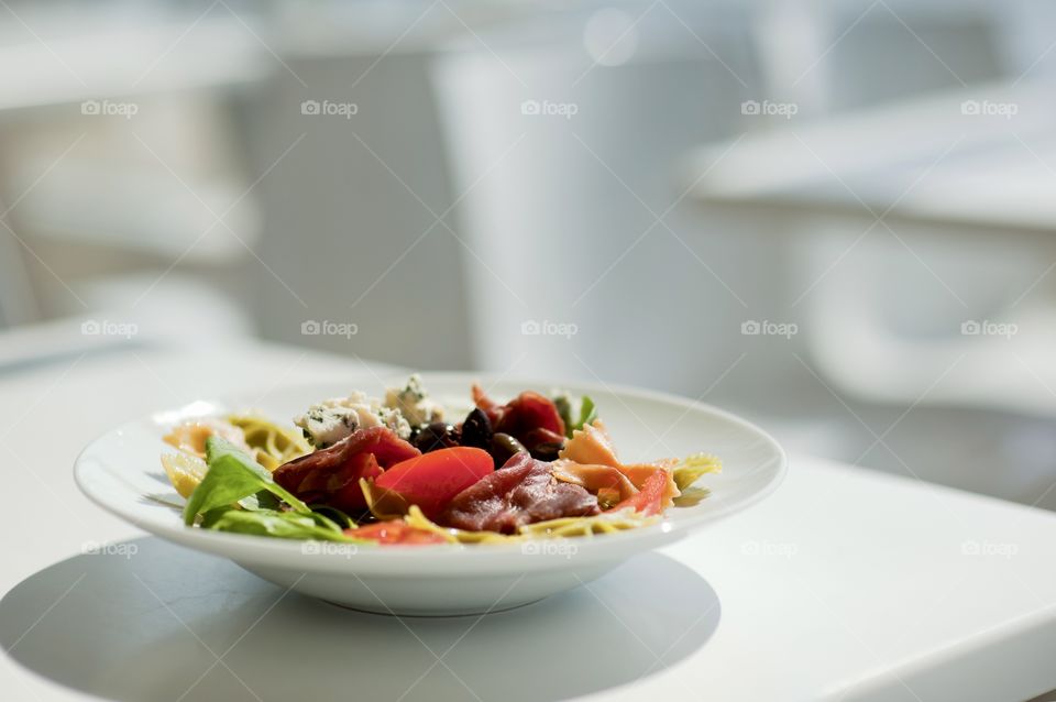 close-up of a young man eating a salad in a light kitchen