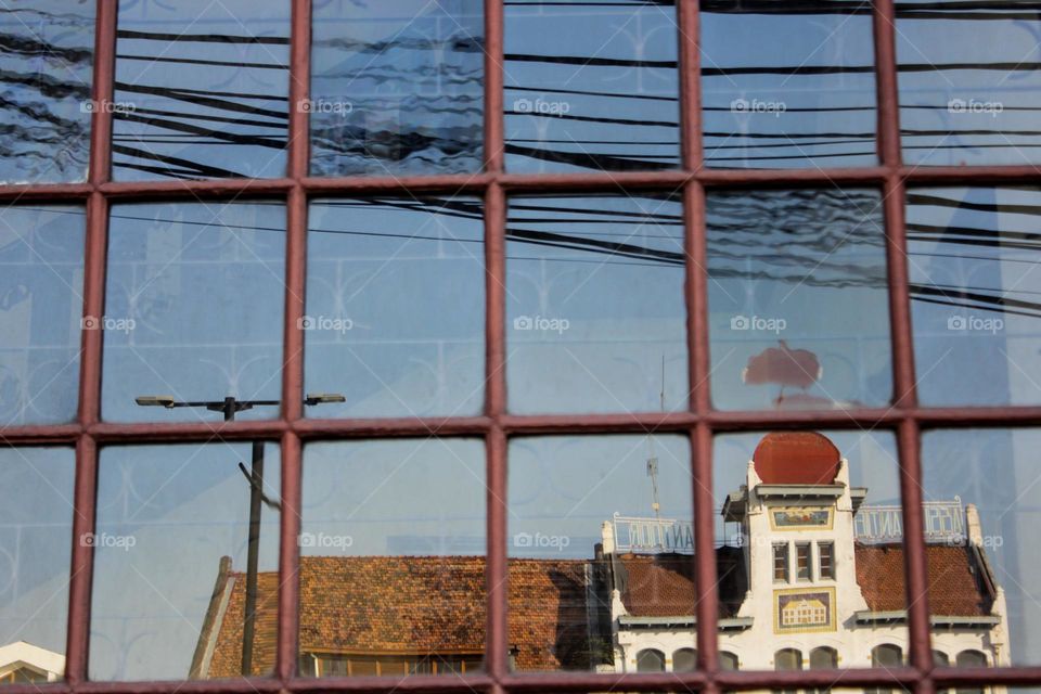 Portrait of a typical Dutch colonial heritage from the reflection of a window glass of a shop in the old city of Jakarta.