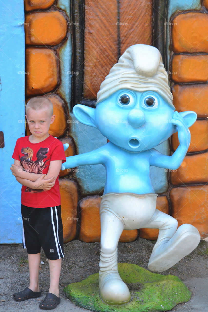 Funny portrait with a boy and smurf sculpture