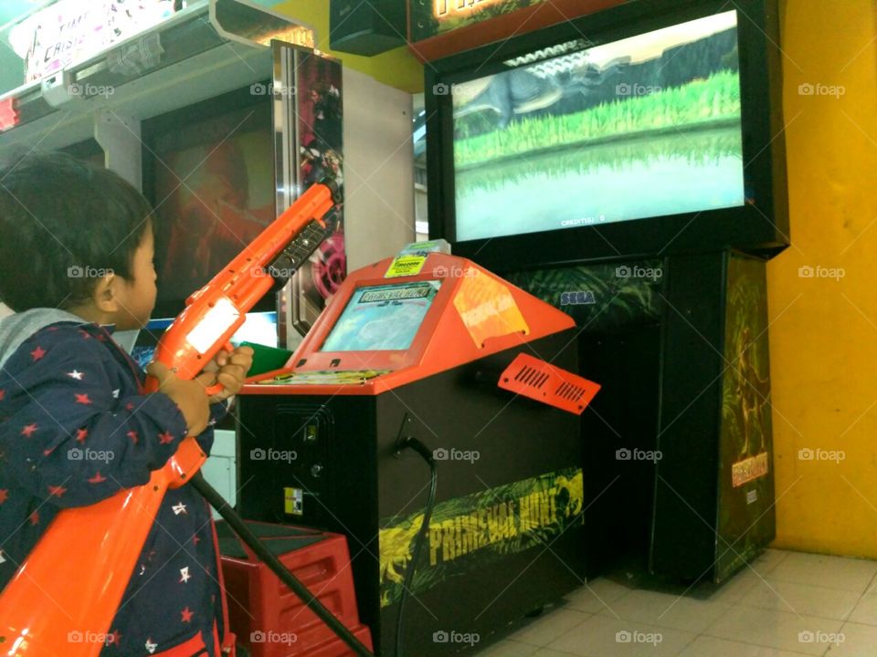 a boy enjoy playing at game zone