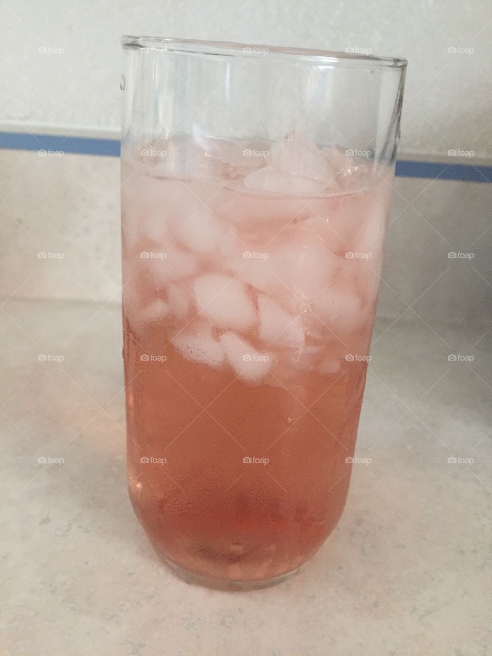 Refreshing flavored water. Glass of crushed ice with splash of cranberry juice