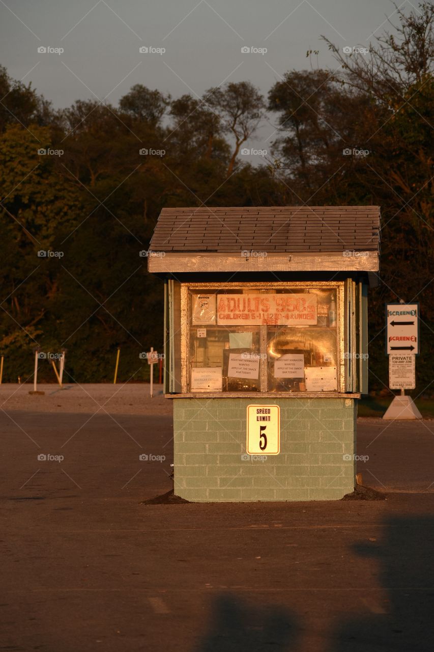 Drive in movie ticket booth in autumn in warm late evening sunlight 